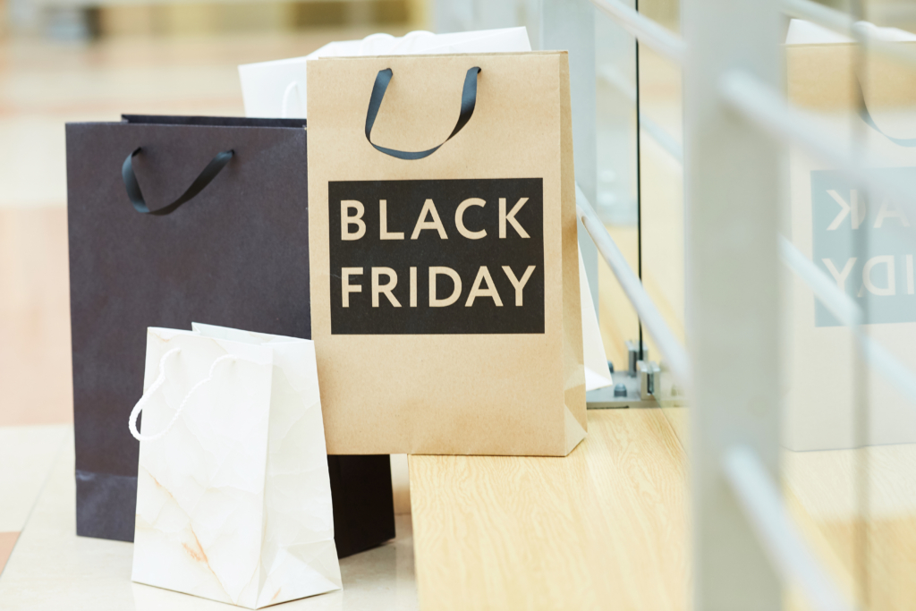 Nahaufnahme von Papier-Einkaufstüten, eine ist bedruckt mit der Aufschrift Black Friday.