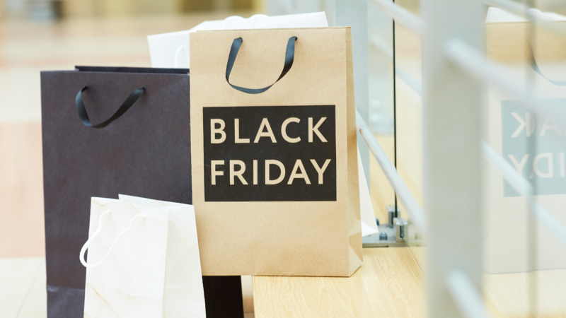 Nahaufnahme von Papier-Einkaufstüten, eine ist bedruckt mit der Aufschrift Black Friday.