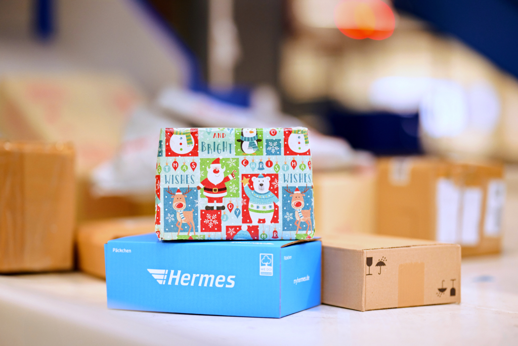Weihnachtspäckchen und -paketen stapeln sich auf einem Laufband im Hermes-Depot (Foto: Hermes Germany / Willing-Holtz)