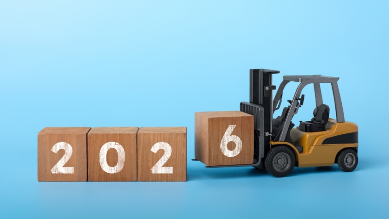 Ein Mini-Bagger stapelt 2026 aus Holzbaukästen.